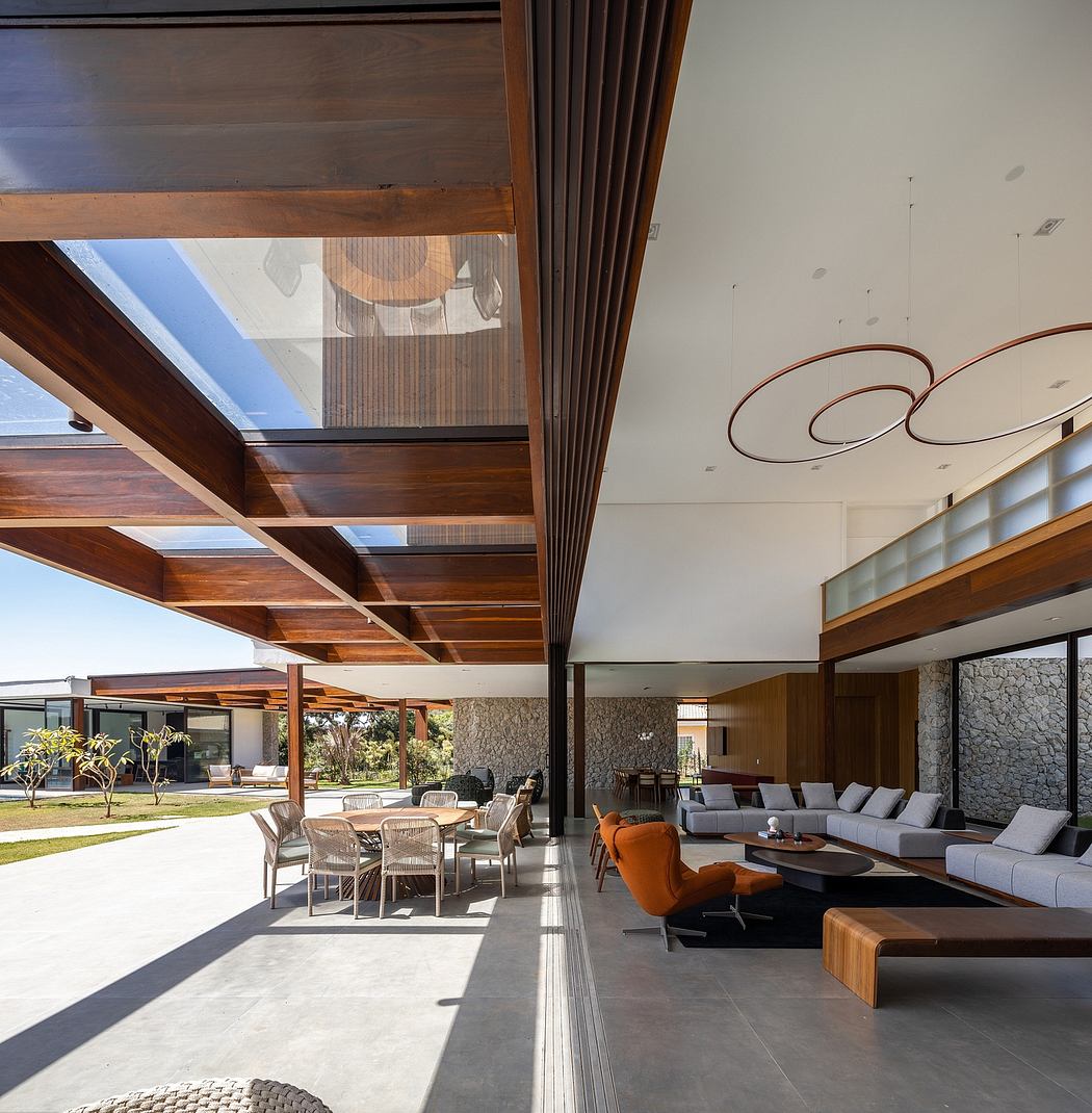 Modern living room with large glass doors, wooden ceiling, and sleek furniture.