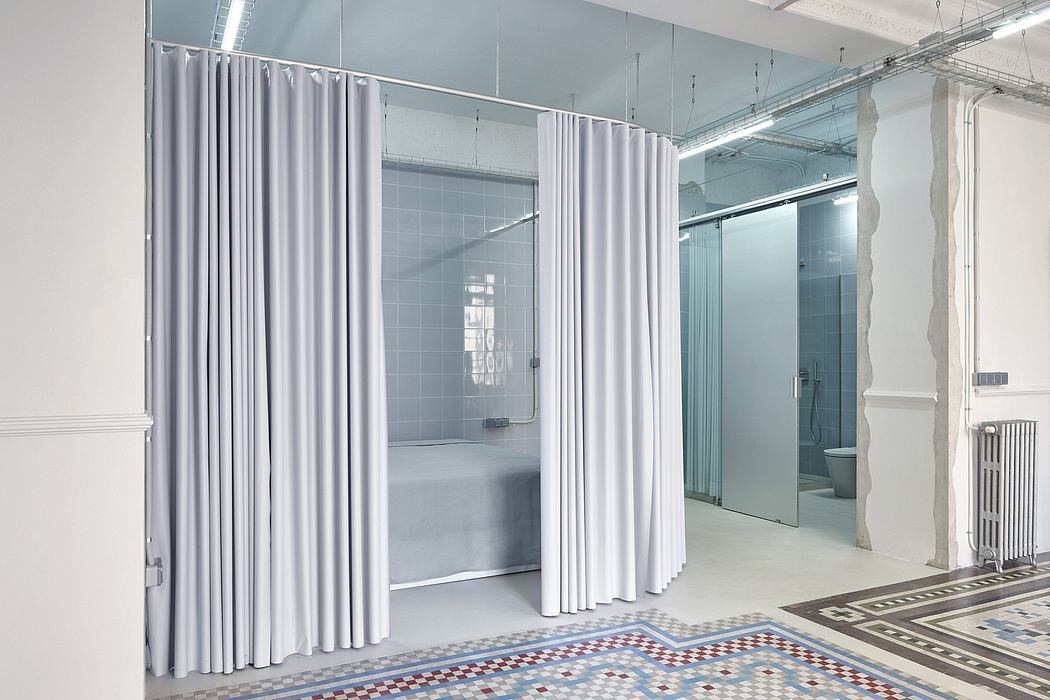 Spacious, industrial-style bathroom with curtain partitions, tiled floors, and modern fixtures.