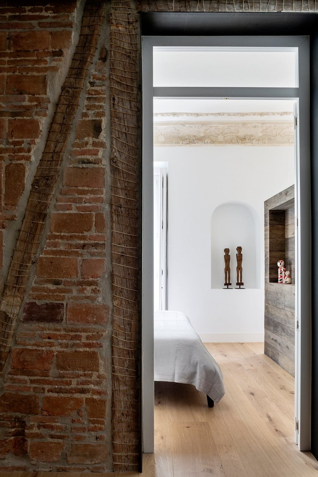 Exposed brick walls, wooden floorboards, and minimalist decor create a cozy yet modern ambiance.