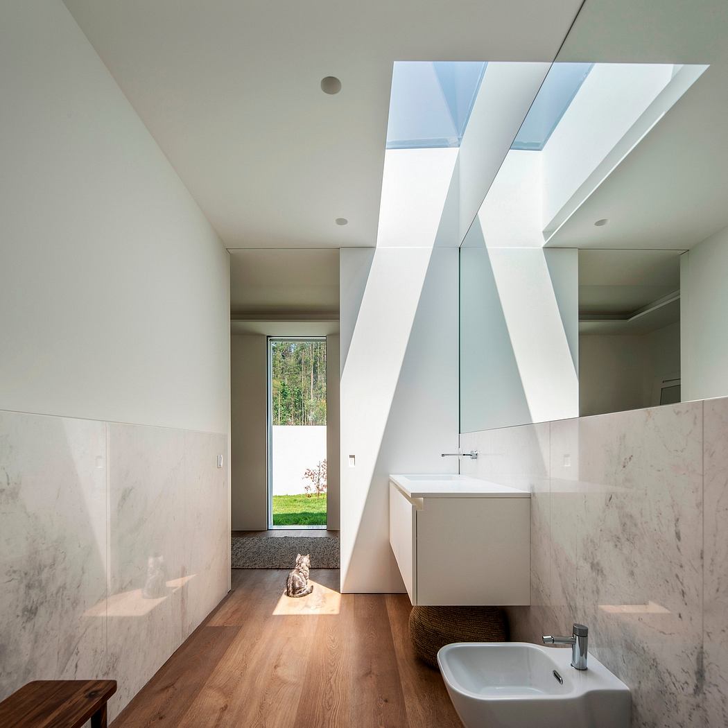 Modern bathroom with marble walls, wooden floor, and geometric skylight.