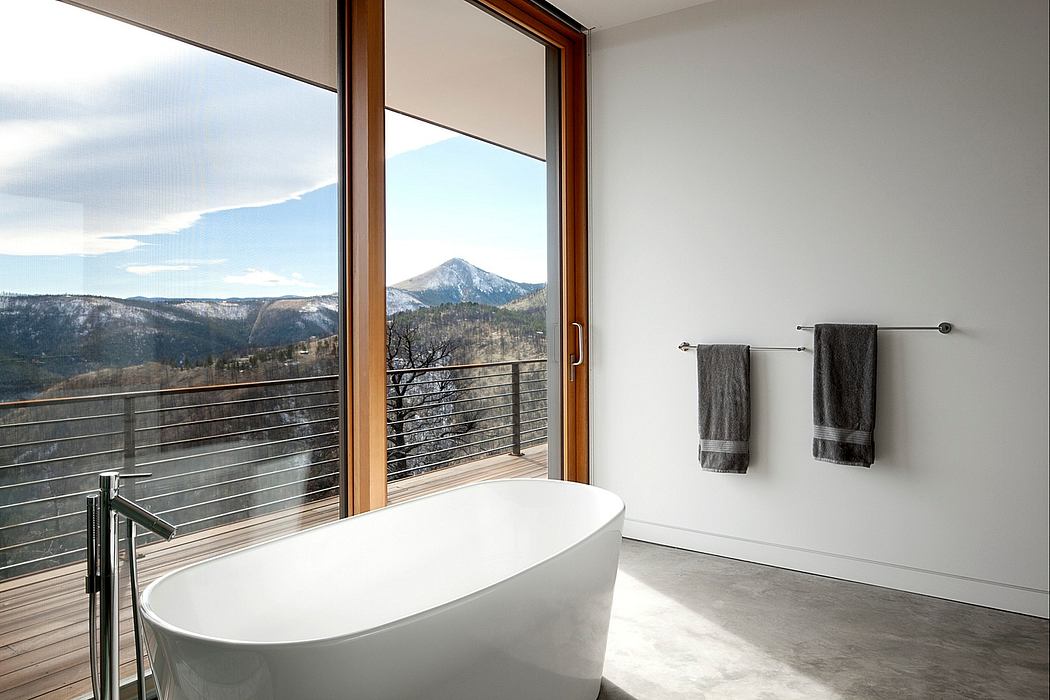Sleek bathroom with freestanding tub and mountain view.