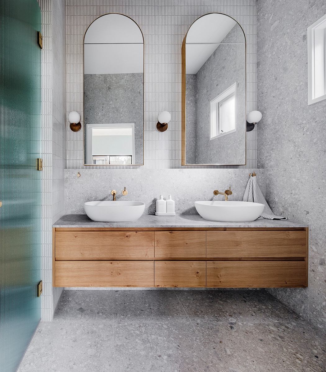 A modern bathroom with a floating vanity, arched mirrors, and a mix of natural materials.