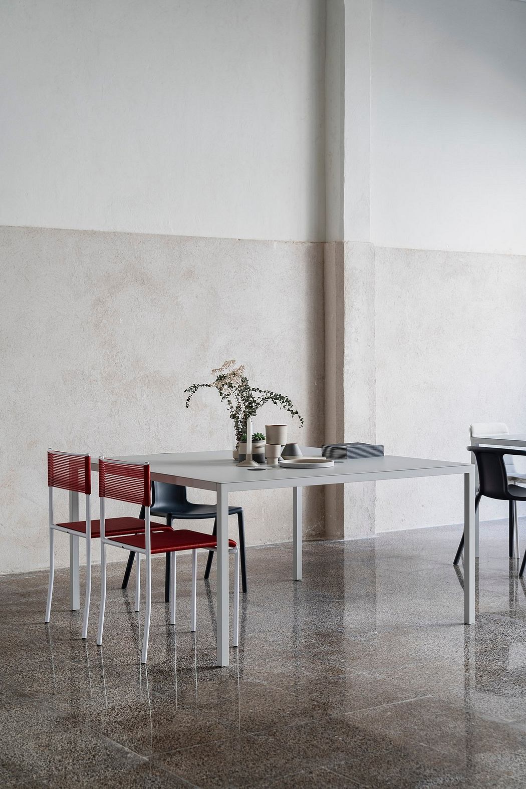 Modern minimalist dining area with sleek table and chairs.