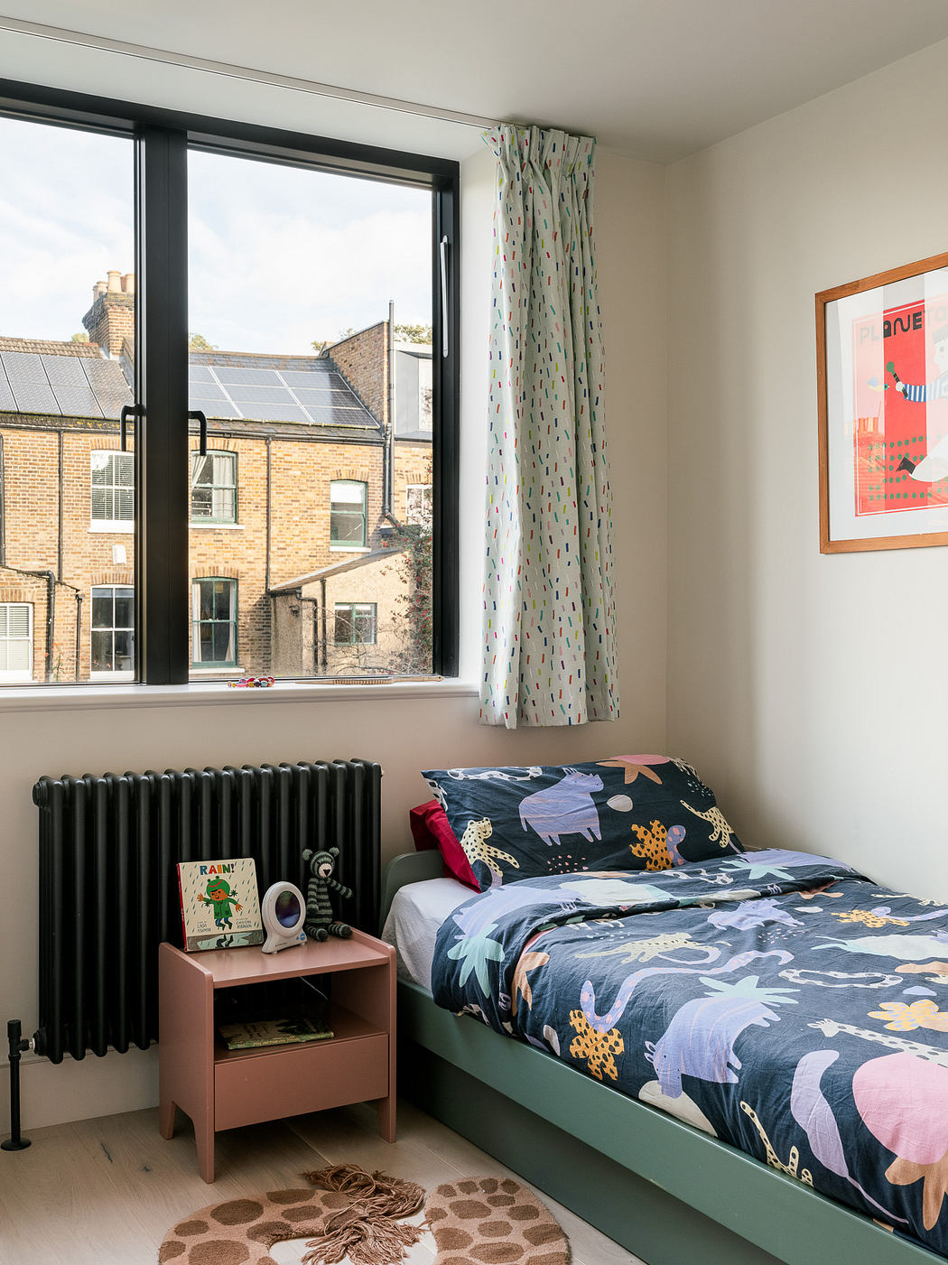 A cozy bedroom with a single bed, floral curtains, and a view of the