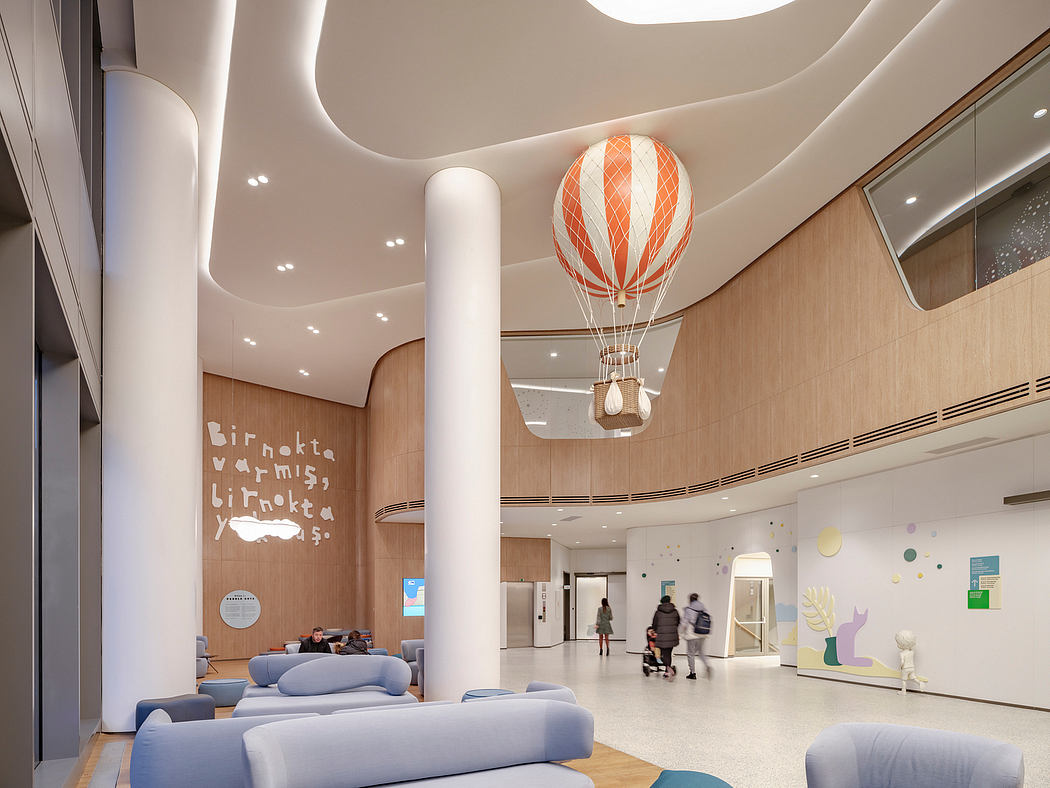 Contemporary lobby with balloon ceiling light, curved white columns, and wooden accents.