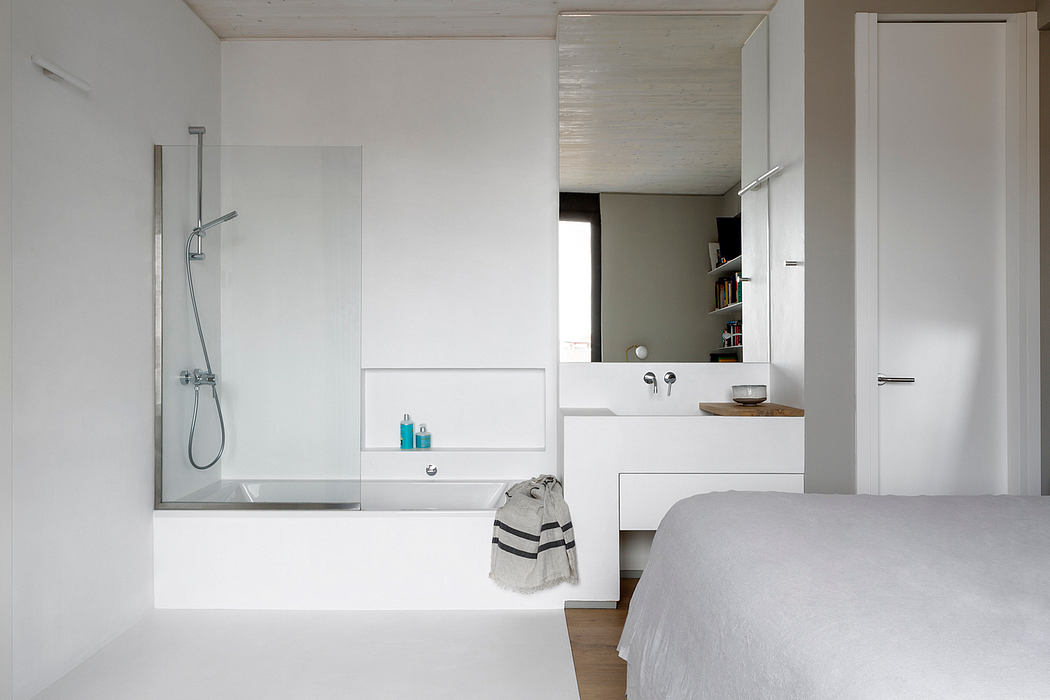 Minimalist bedroom with an open-plan shower and white furnishings.