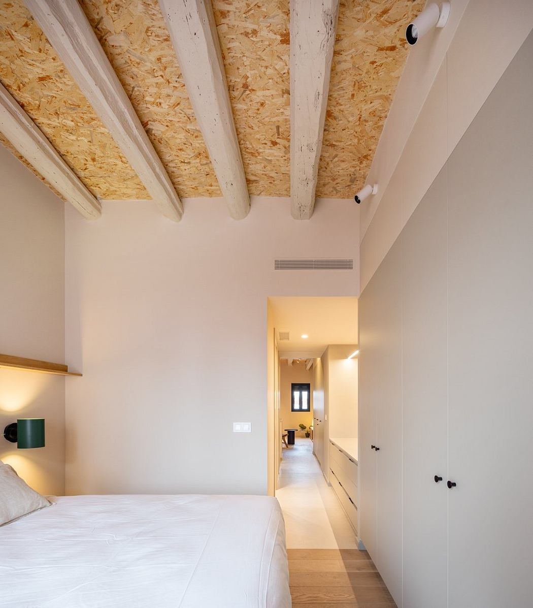 Cozy bedroom with exposed wood beams and minimalist design elements.
