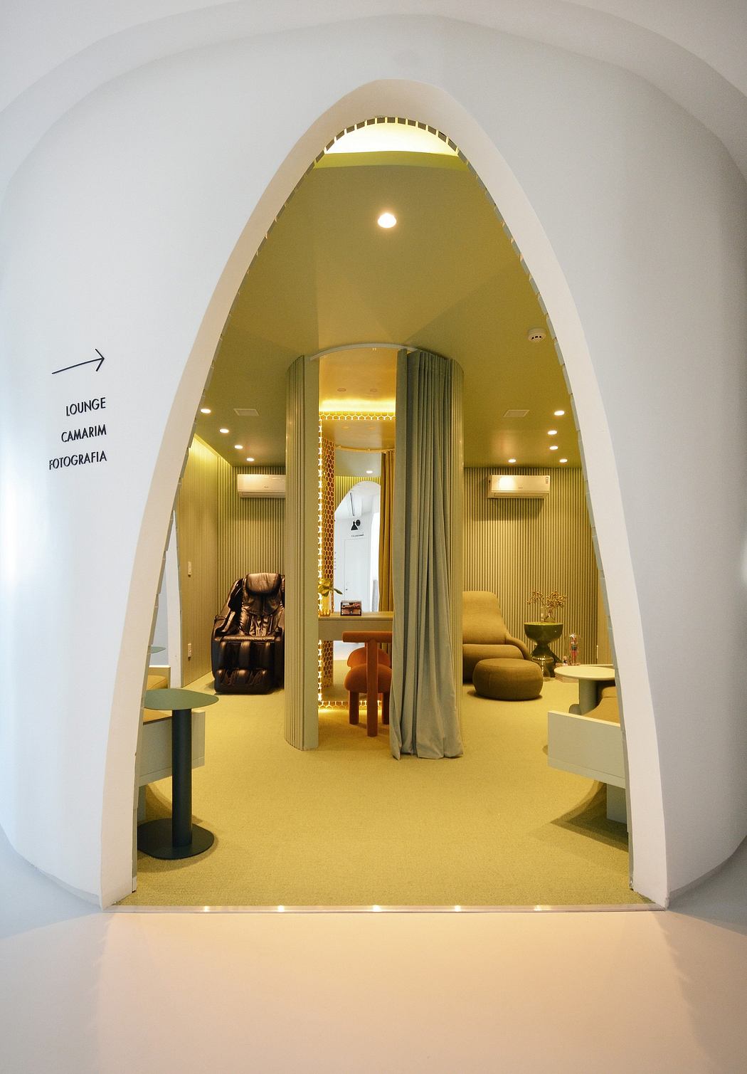 Inviting lounge area with warm lighting, plush seating, and a curtained alcove.