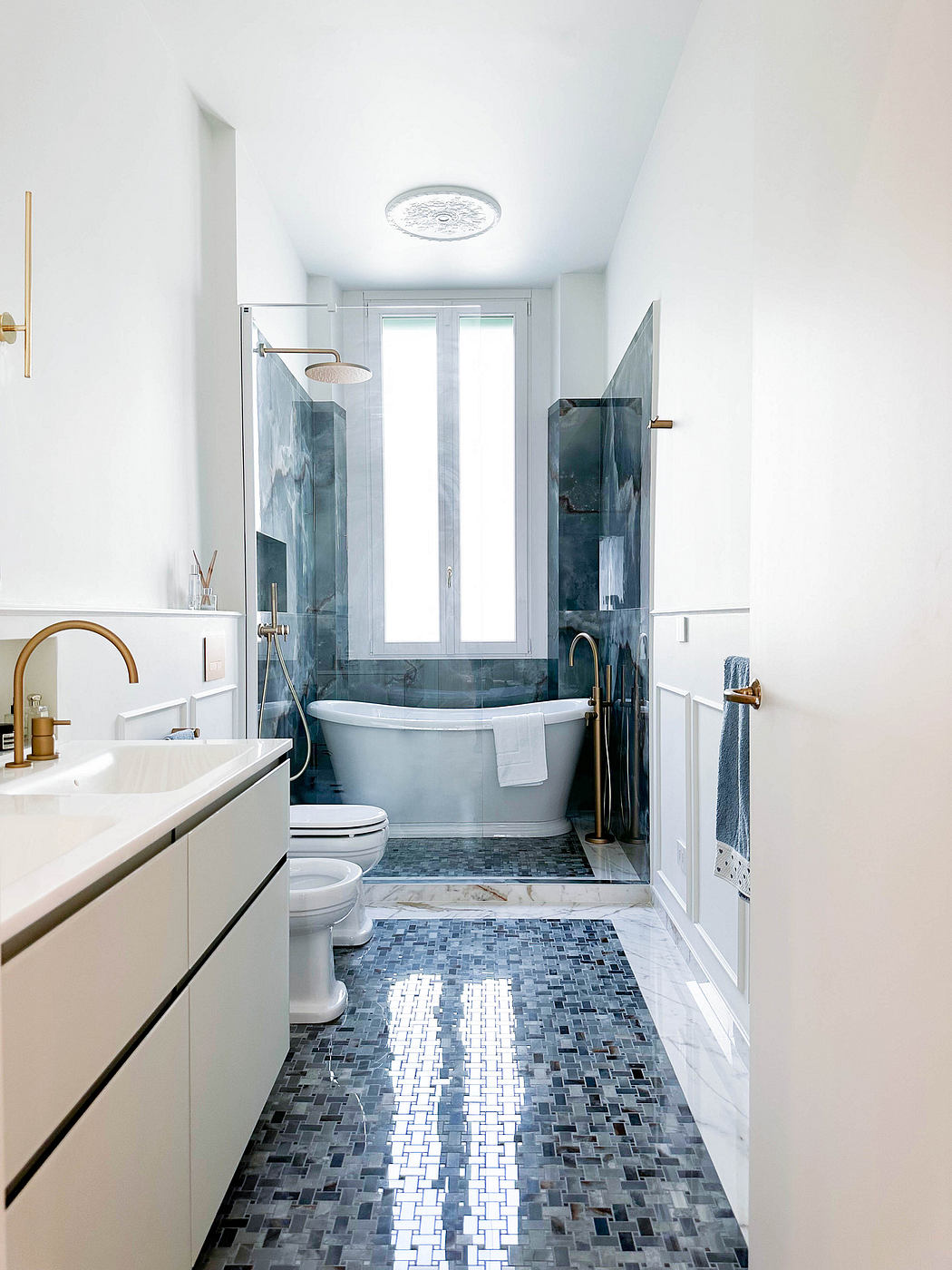 Sleek white bathroom with marble accents and gold fixtures.