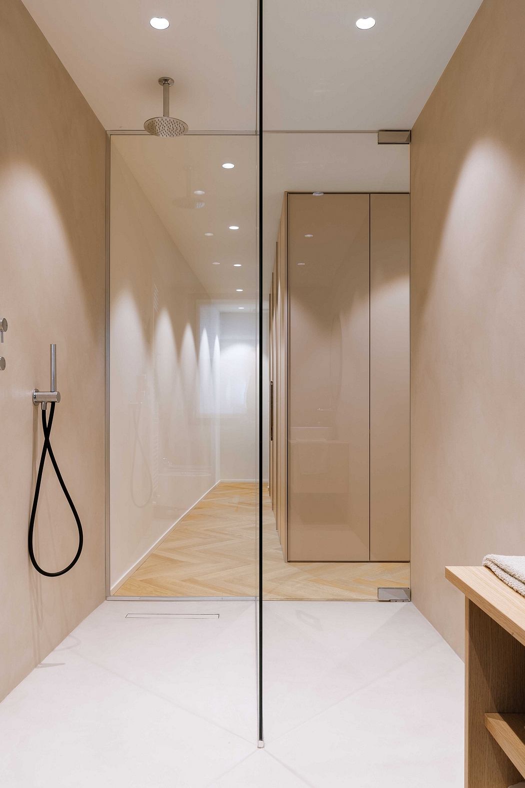 Sleek, beige-toned bathroom with glass shower and minimalist design.