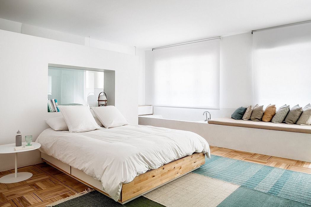 Minimalist bedroom design with wooden platform bed, built-in seating, and natural light.