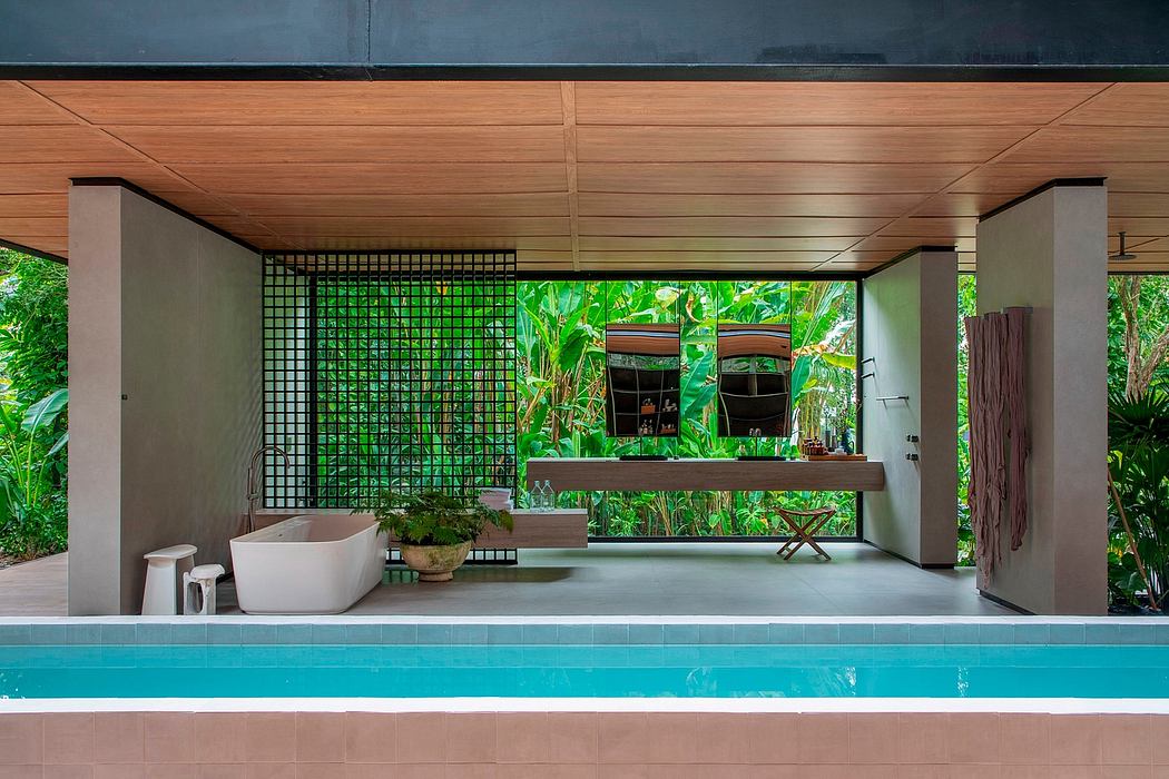 Modern bathroom with an open wall facing lush greenery and a pool in the foreground