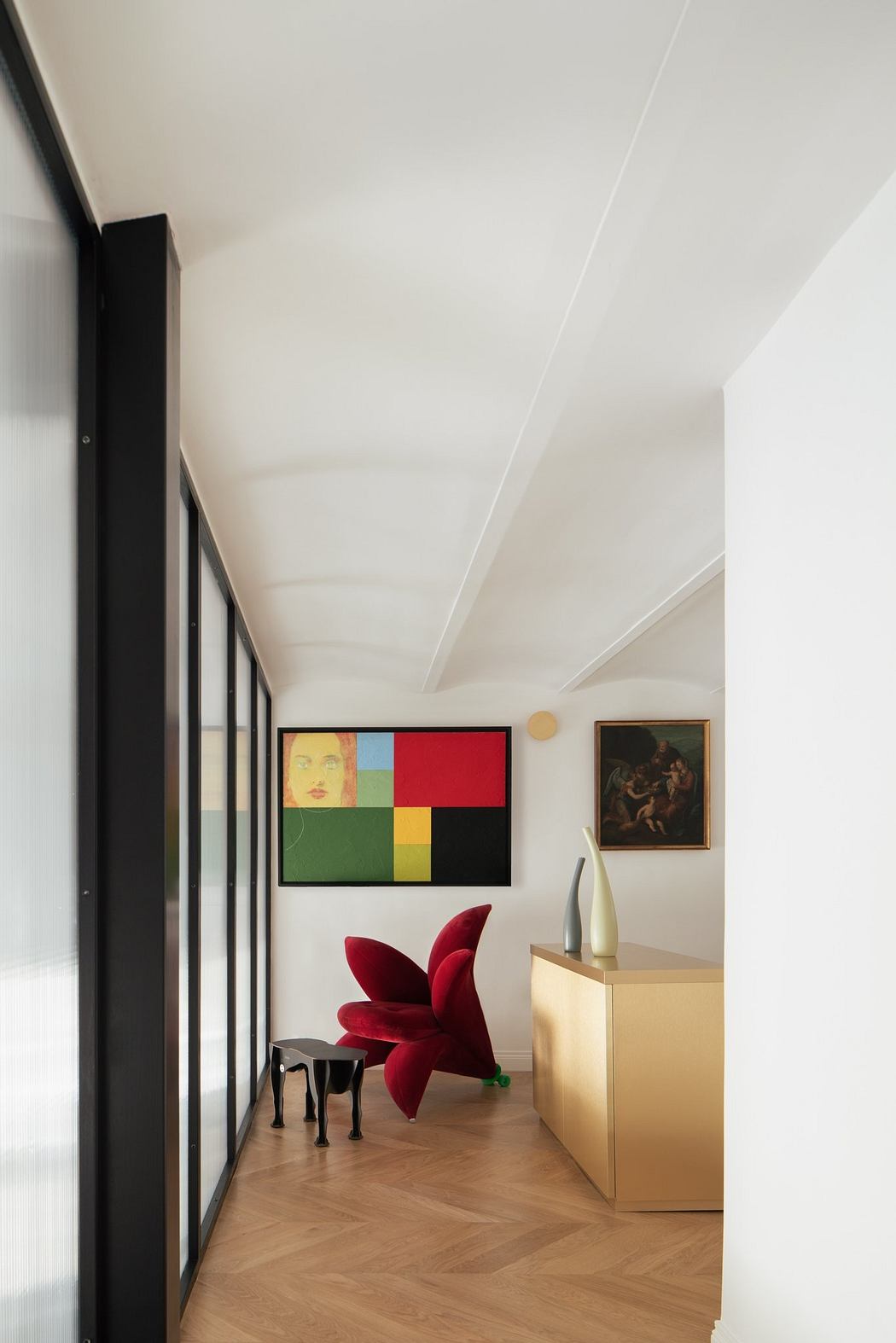 Sleek interior with abstract art, unique red chairs, and a metallic gold