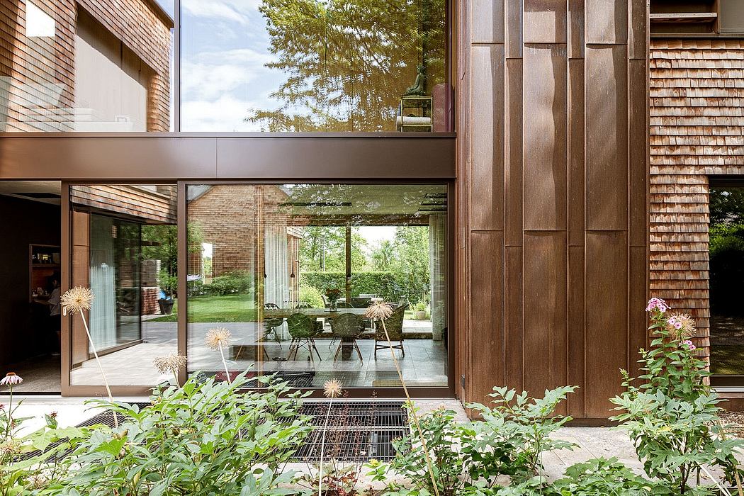 Modern house facade with large glass windows and wooden details.