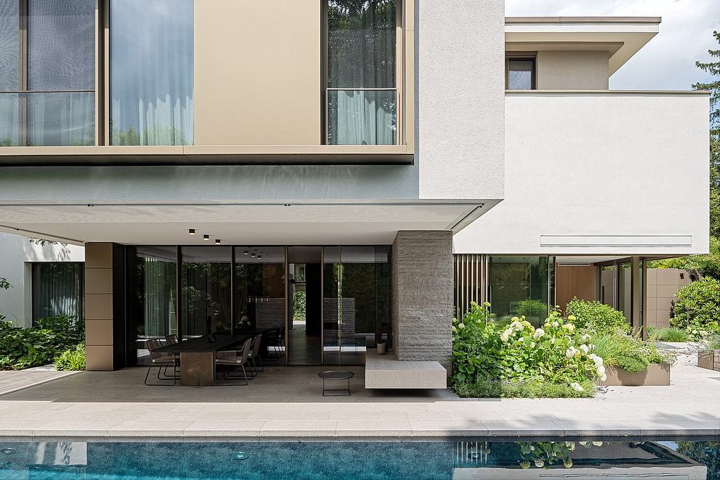 Elegant modern architecture featuring spacious outdoor terrace, glass walls, and landscaping.