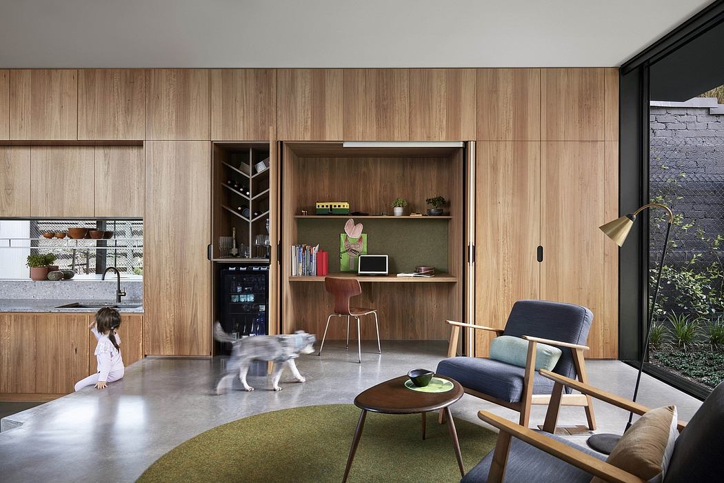 Modern open-plan living space with wooden paneling, built-in shelving, and minimalist furnishings.