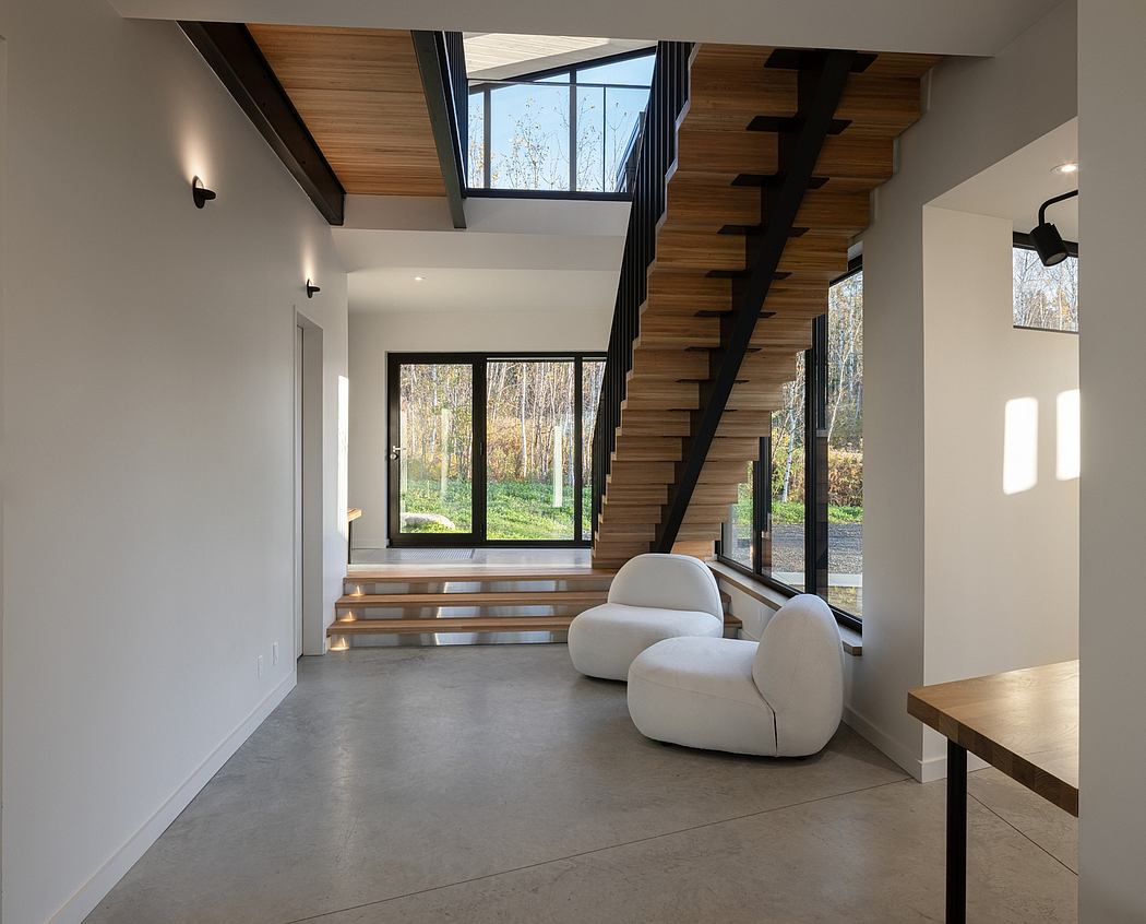 Modern interior with wooden stairs, large windows, and white chairs.