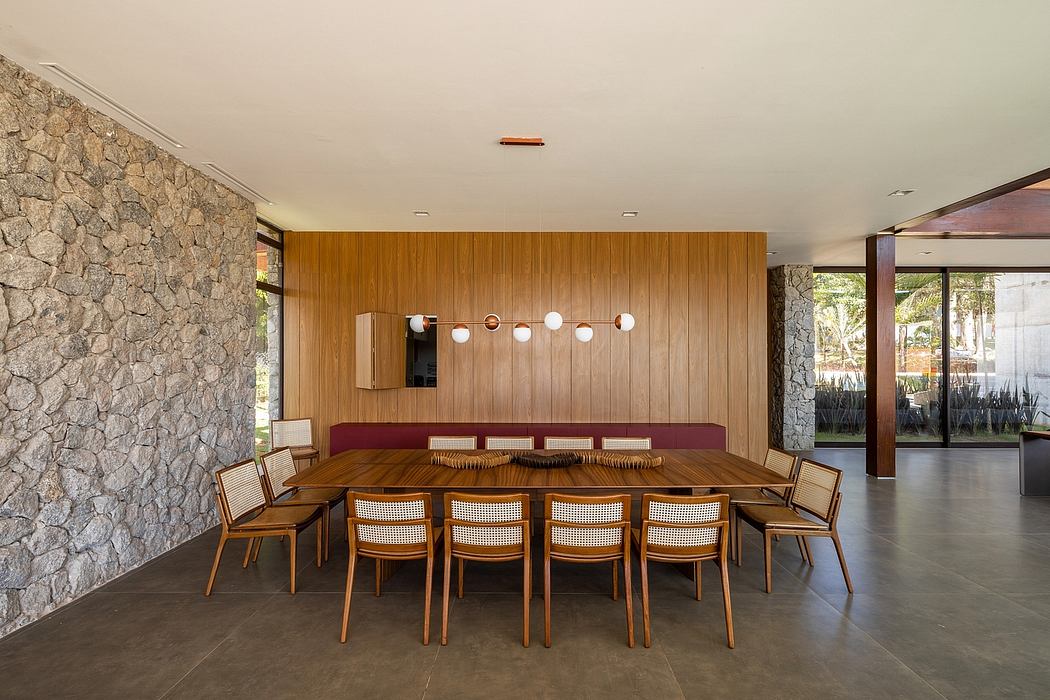 Modern dining room with stone wall, wooden paneling, and long table with chairs