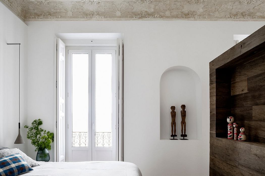 Minimalist bedroom with ornate ceiling, arched niche, and modern wood paneling.