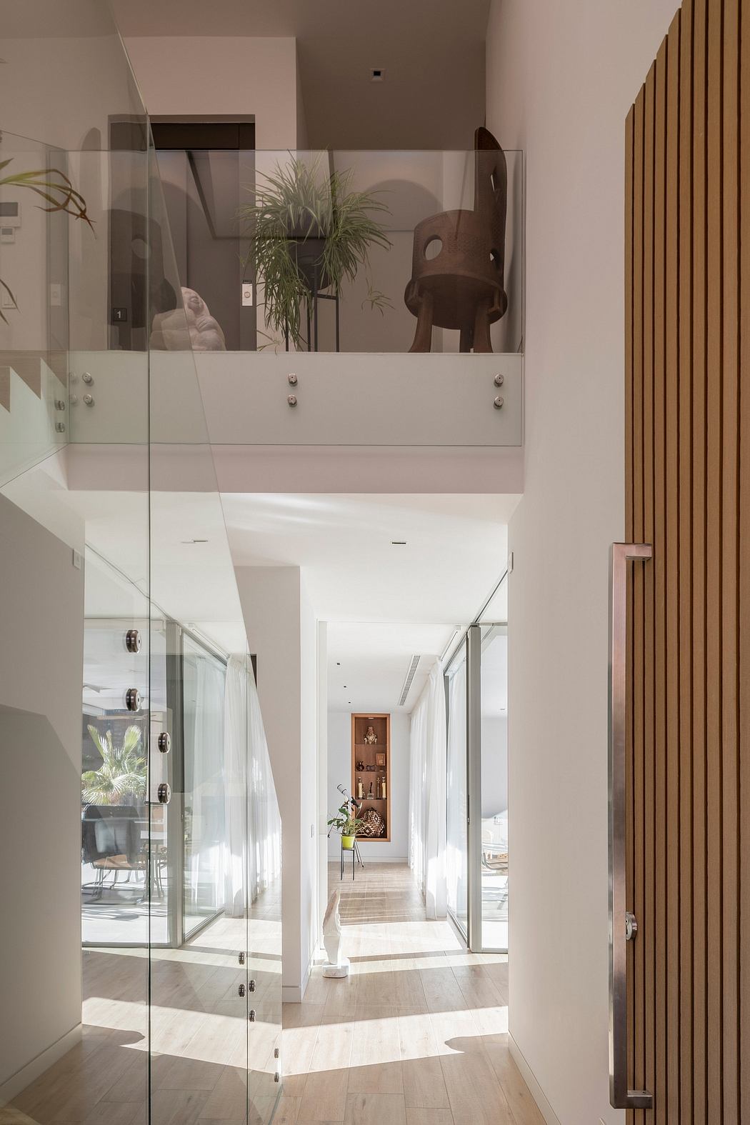 Bright hallway with glass balustrade and sleek wooden elements.