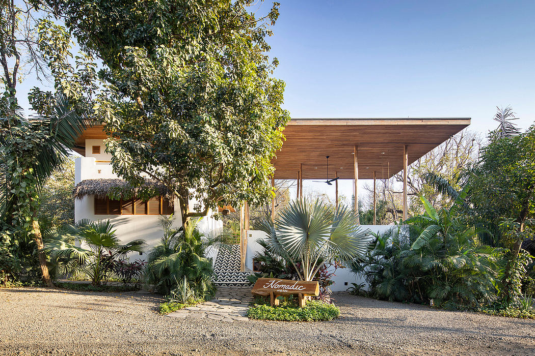 Contemporary house with large overhanging roof and lush garden setting.
