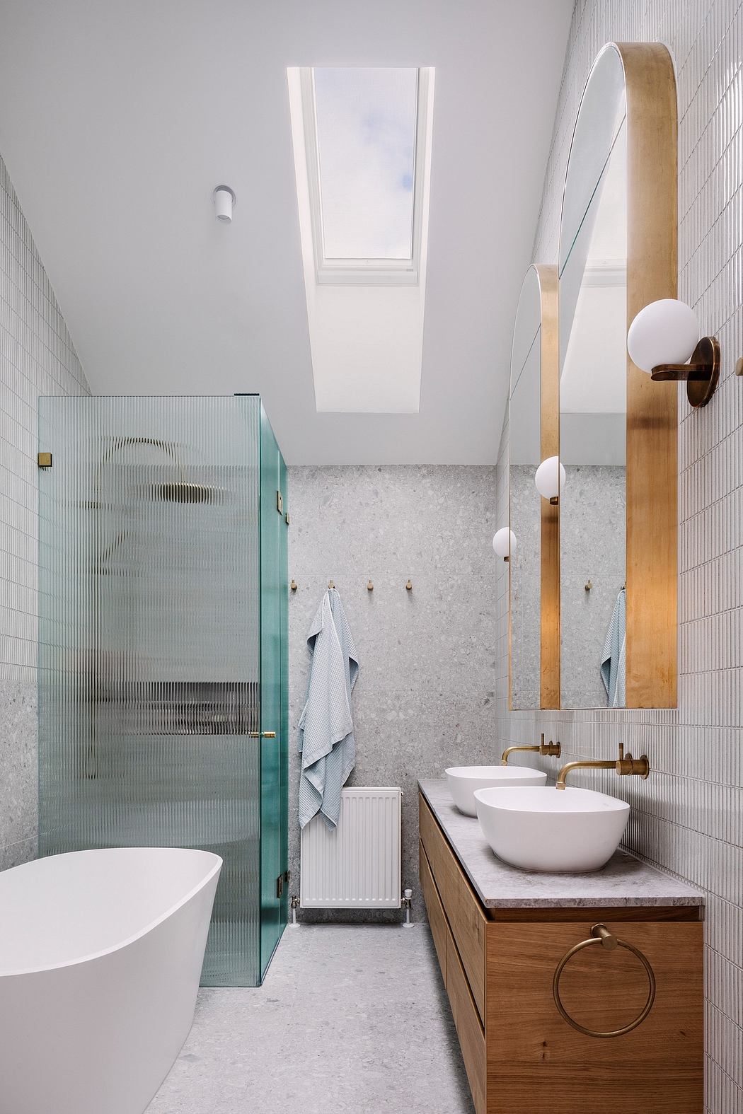 Modern bathroom with glass shower enclosure, wood vanity, and skylights for natural lighting.