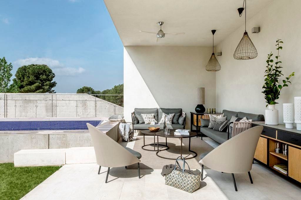 Modern outdoor patio area with furniture and pool.