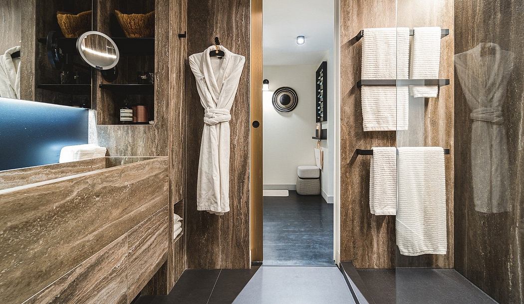 Modern bathroom interior with wooden cabinets and white towels.