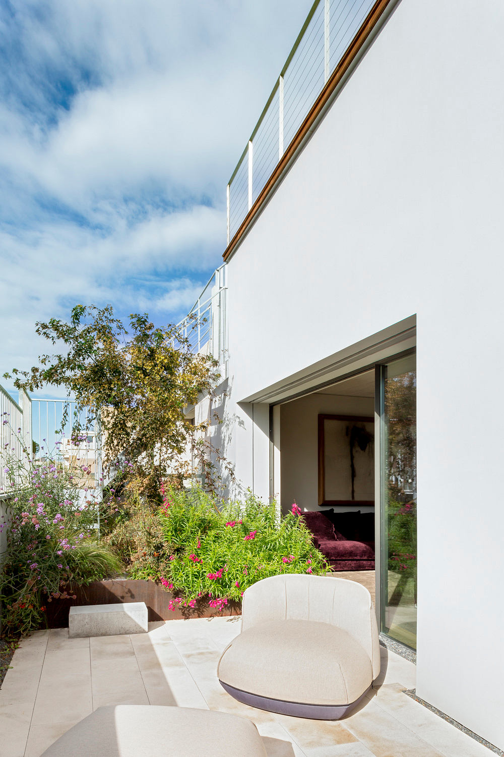 Sleek patio with chair, plants, and sliding door.