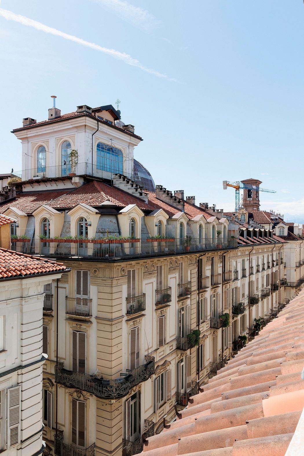 A picturesque rooftop structure with arched windows and intricate balconies overlooking a historic city.