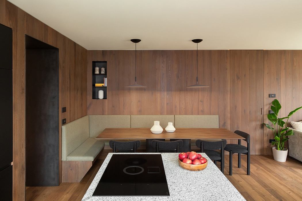 Modern kitchen with wooden walls, built-in table, and bench seating.