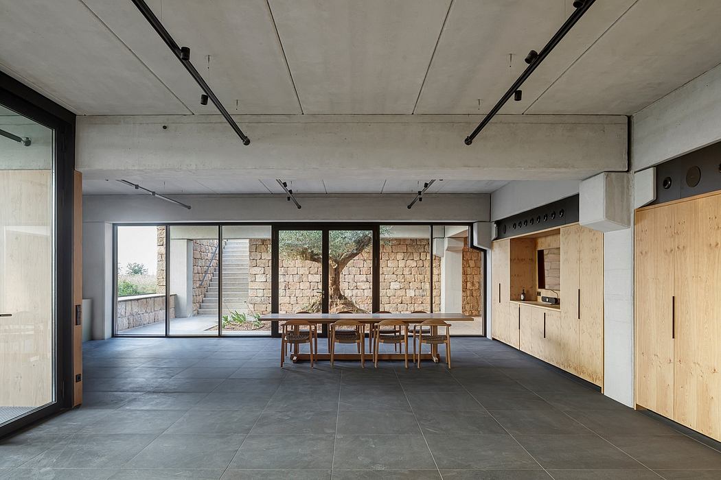 Minimalist interior with concrete ceiling, large windows, and wooden accents.