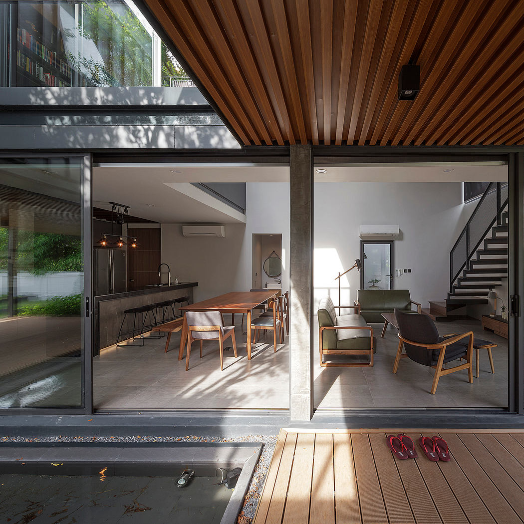 Intimate living space with wooden ceiling, expansive glass windows, and stylish furnishings.