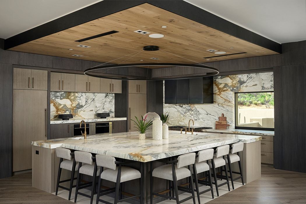 A modern, open-concept kitchen with sleek cabinetry, marble countertops, and a distinctive wood-paneled ceiling.