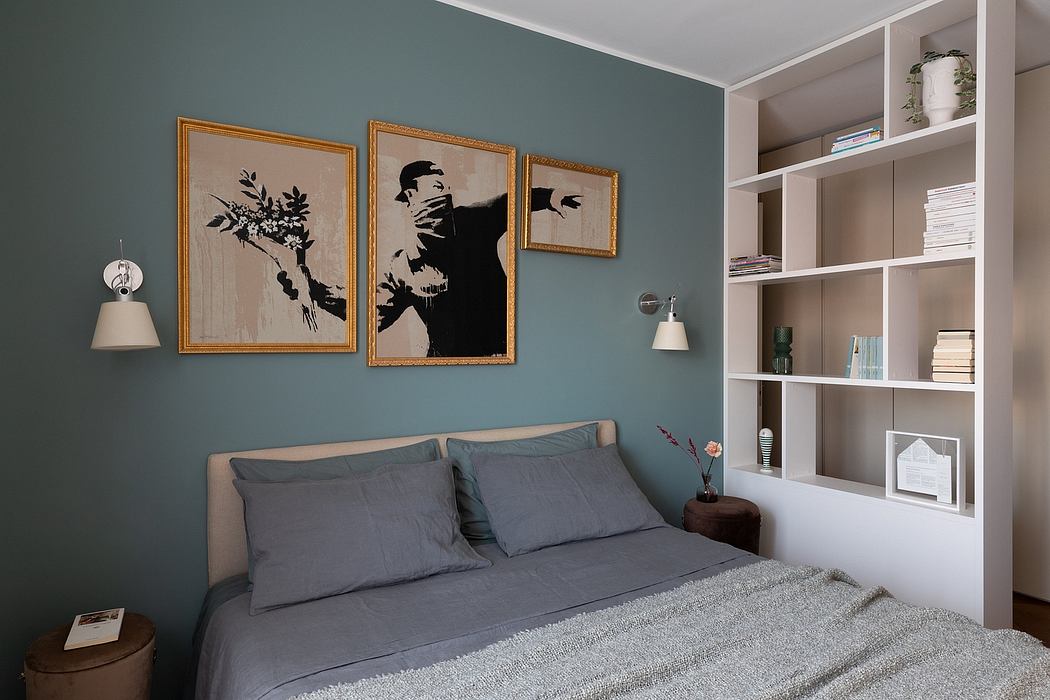 Contemporary bedroom with teal walls, framed art, and built-in shelving.