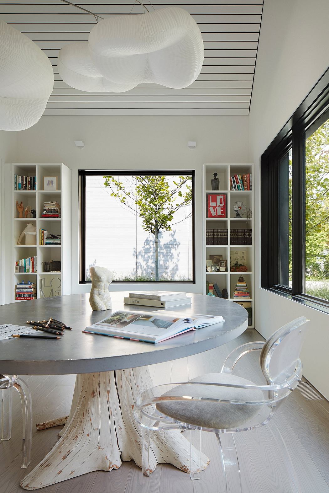 Contemporary room with unique tree-base table and translucent chairs.