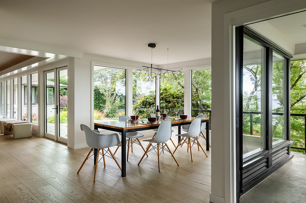 Bright, modern dining room with sleek furniture and large windows overlooking lush greenery.
