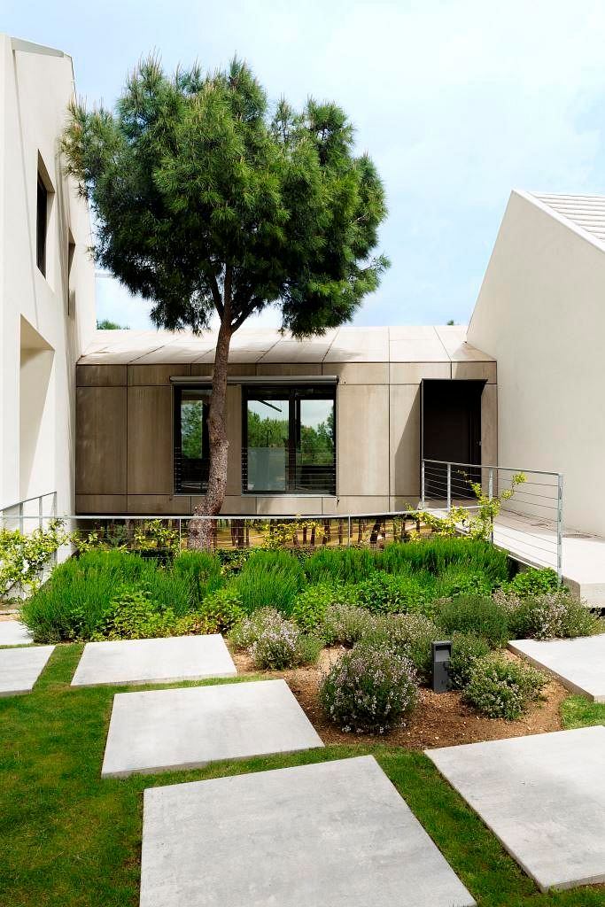 Modern home exterior with geometric garden pathway and landscaping.