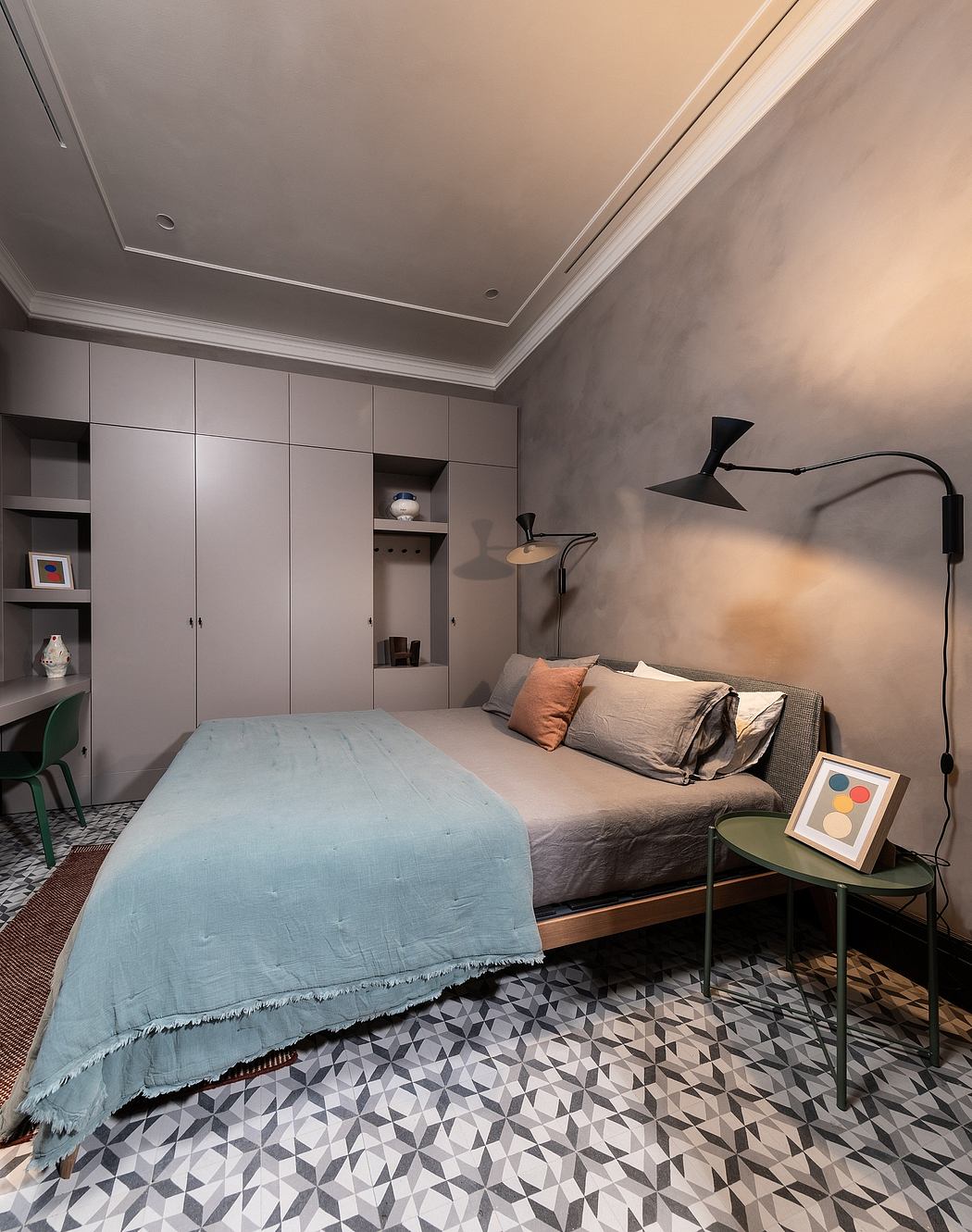 Modern bedroom with a blue bedspread, patterned floor, and built-in closet