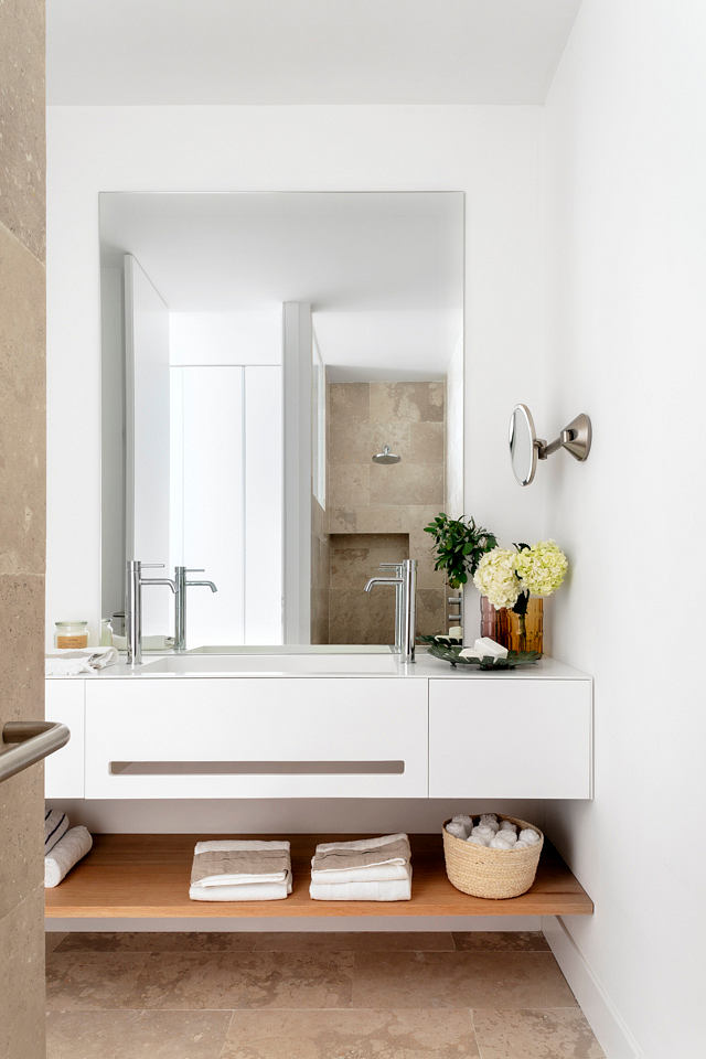 Minimalist bathroom with floating vanity and beige tiles.