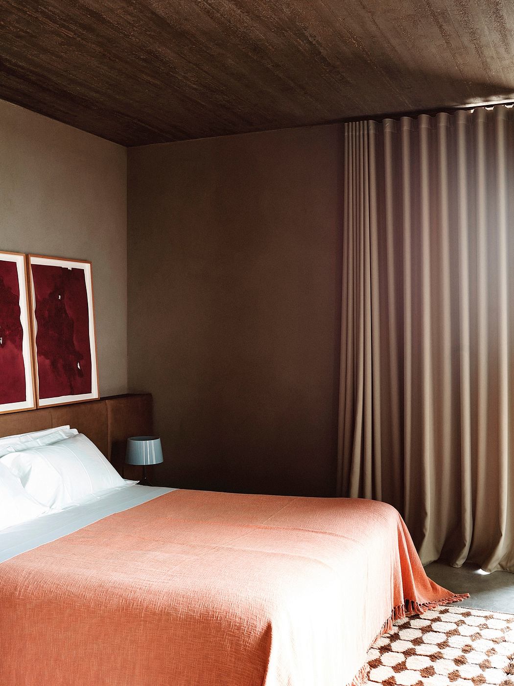 Modern bedroom with terracotta bedding and minimalist decor.