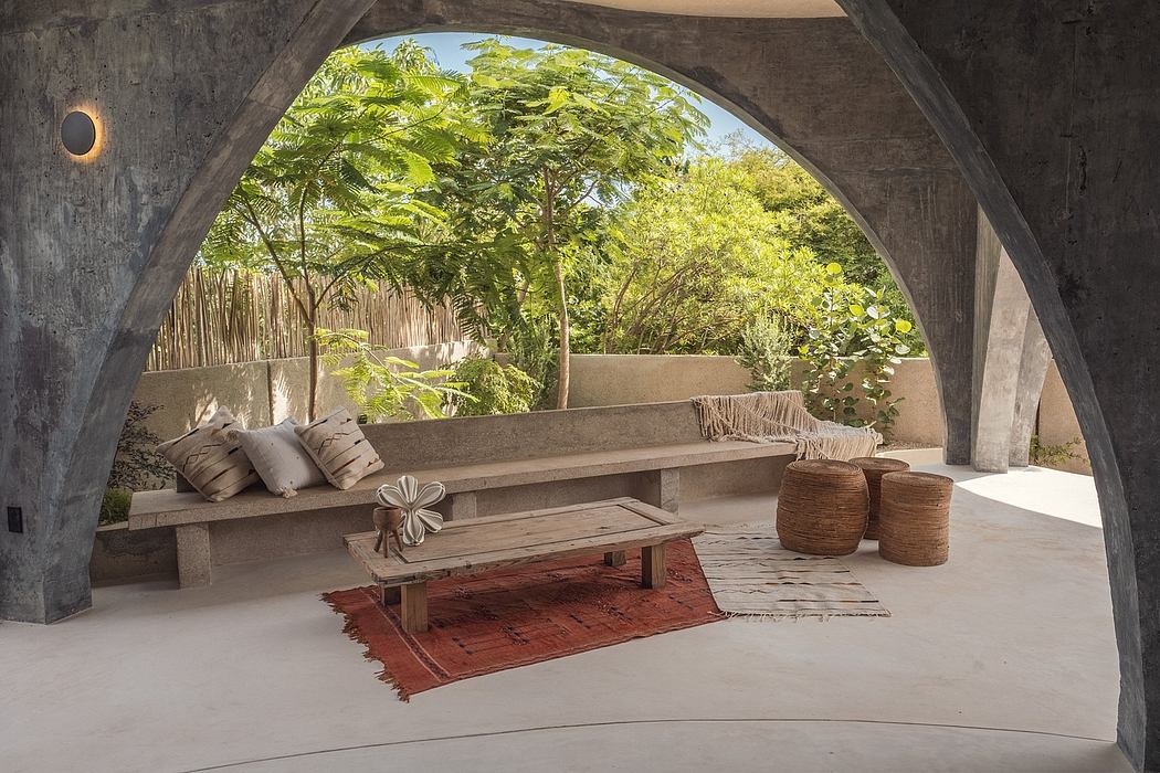 Inviting stone archway leads to a cozy, nature-infused outdoor living space with plush seating and decorative elements.