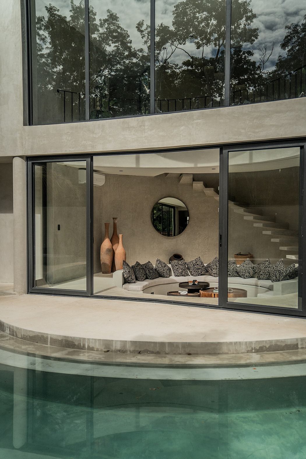 Modern house with large windows overlooking a pool.