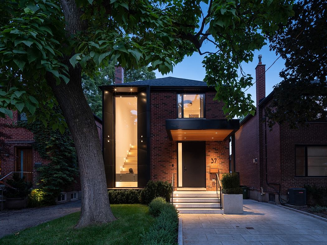 Modern house with large windows at twilight, surrounded by trees.