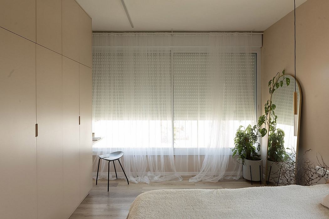 Minimalist bedroom with sheer curtains and built-in wardrobes