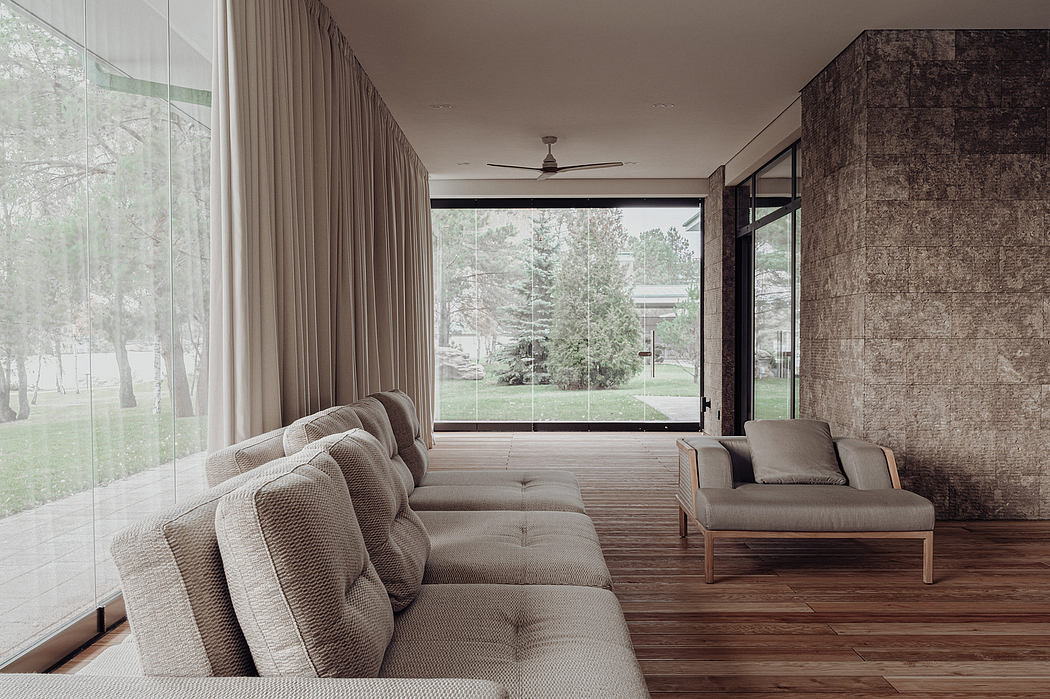 Spacious modern living room with large windows, textured walls, and plush seating.