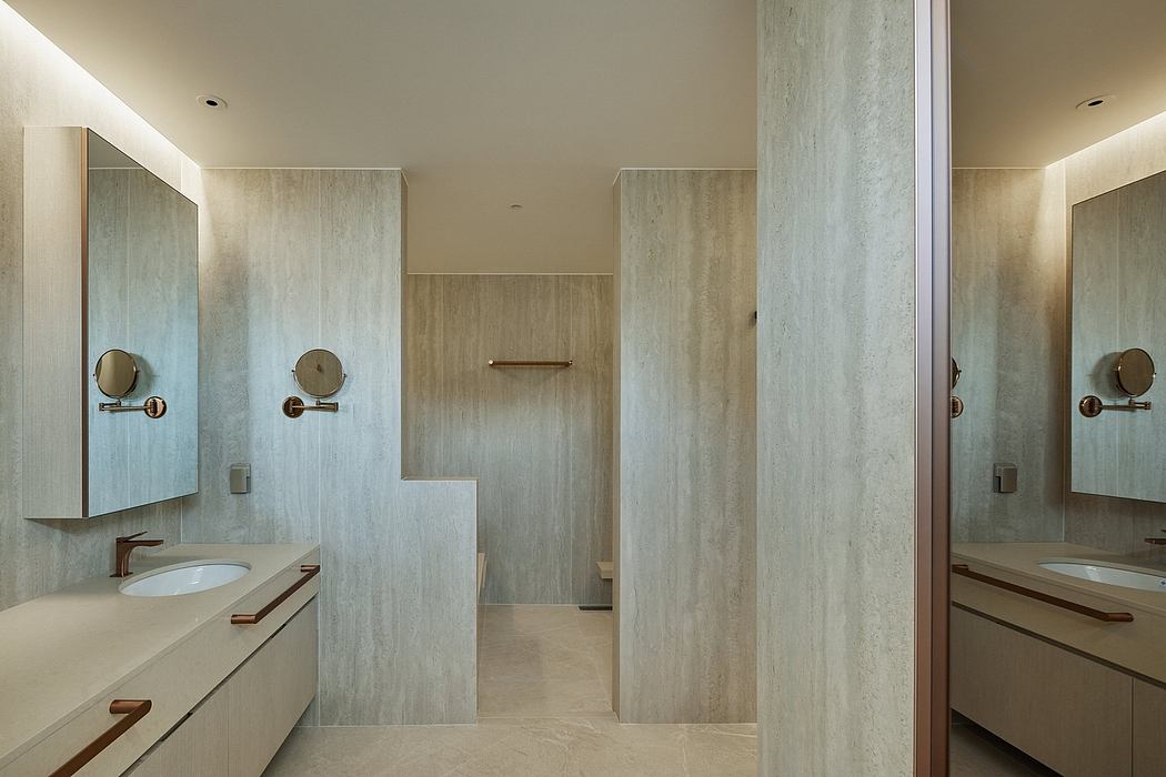 Sleek bathroom with light wood tones and dual vanities.