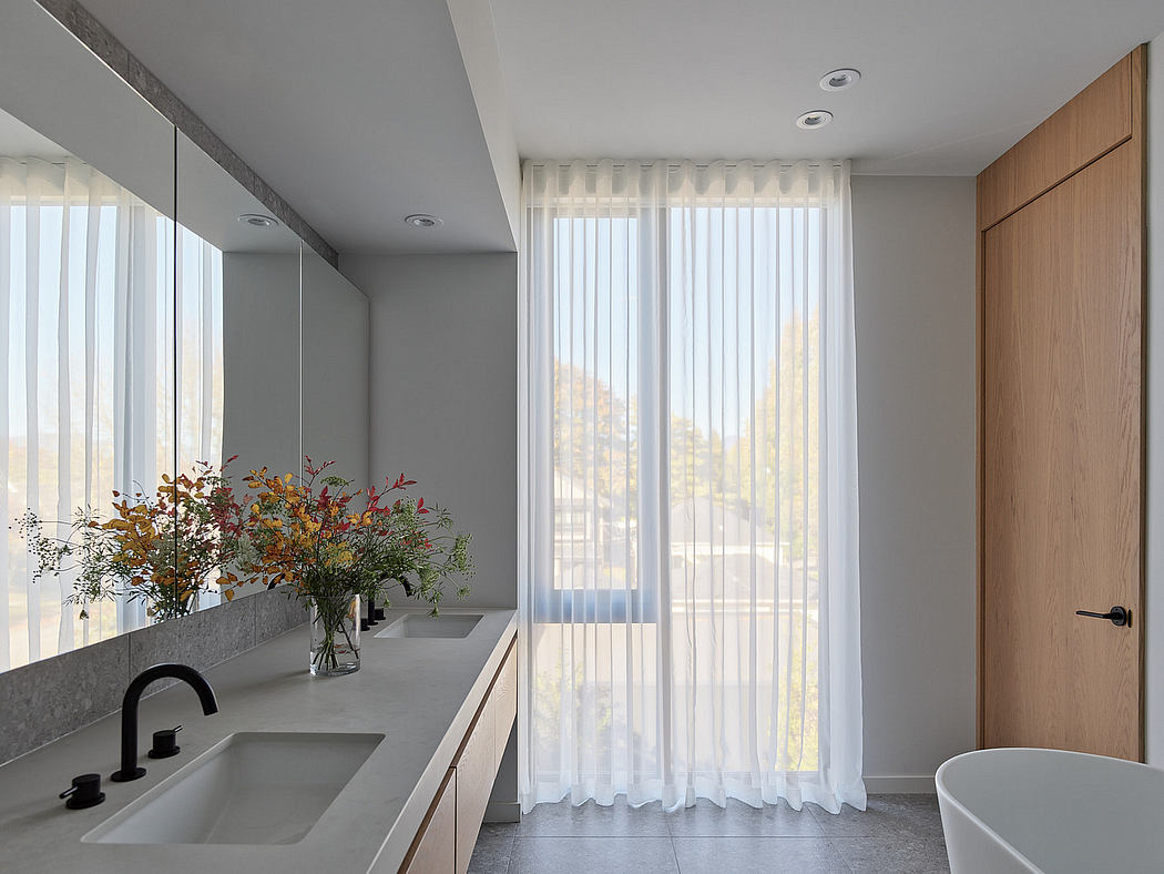 Minimalist bathroom with large window, sheer curtains, and wooden accents.
