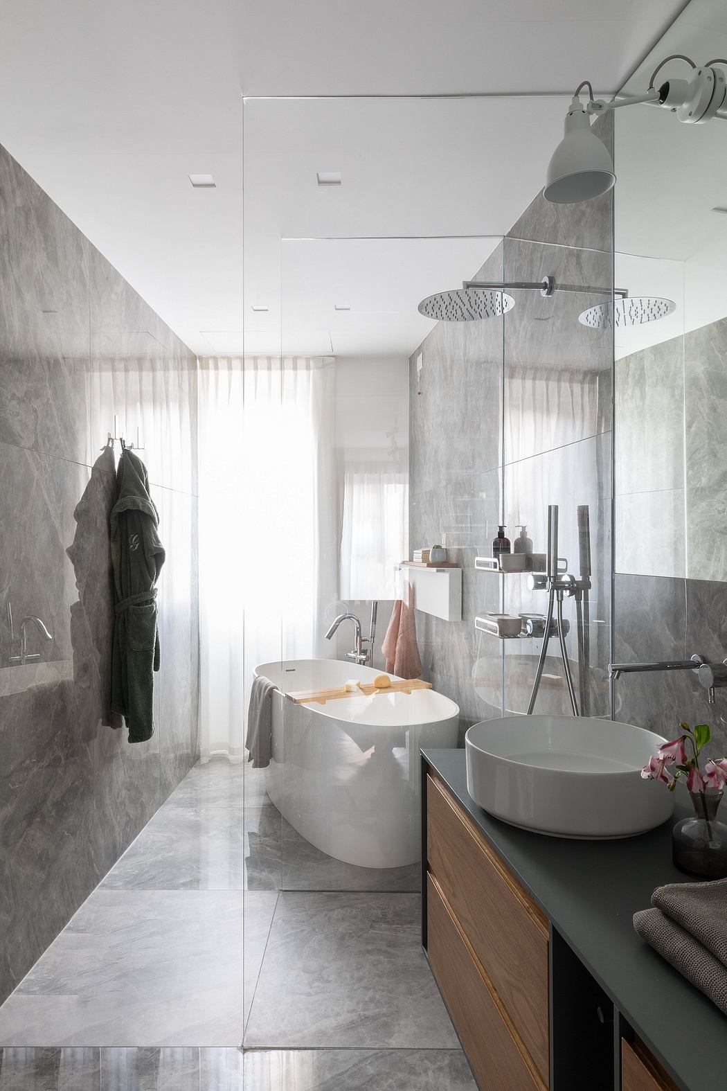 Sleek bathroom with freestanding tub and marble walls.