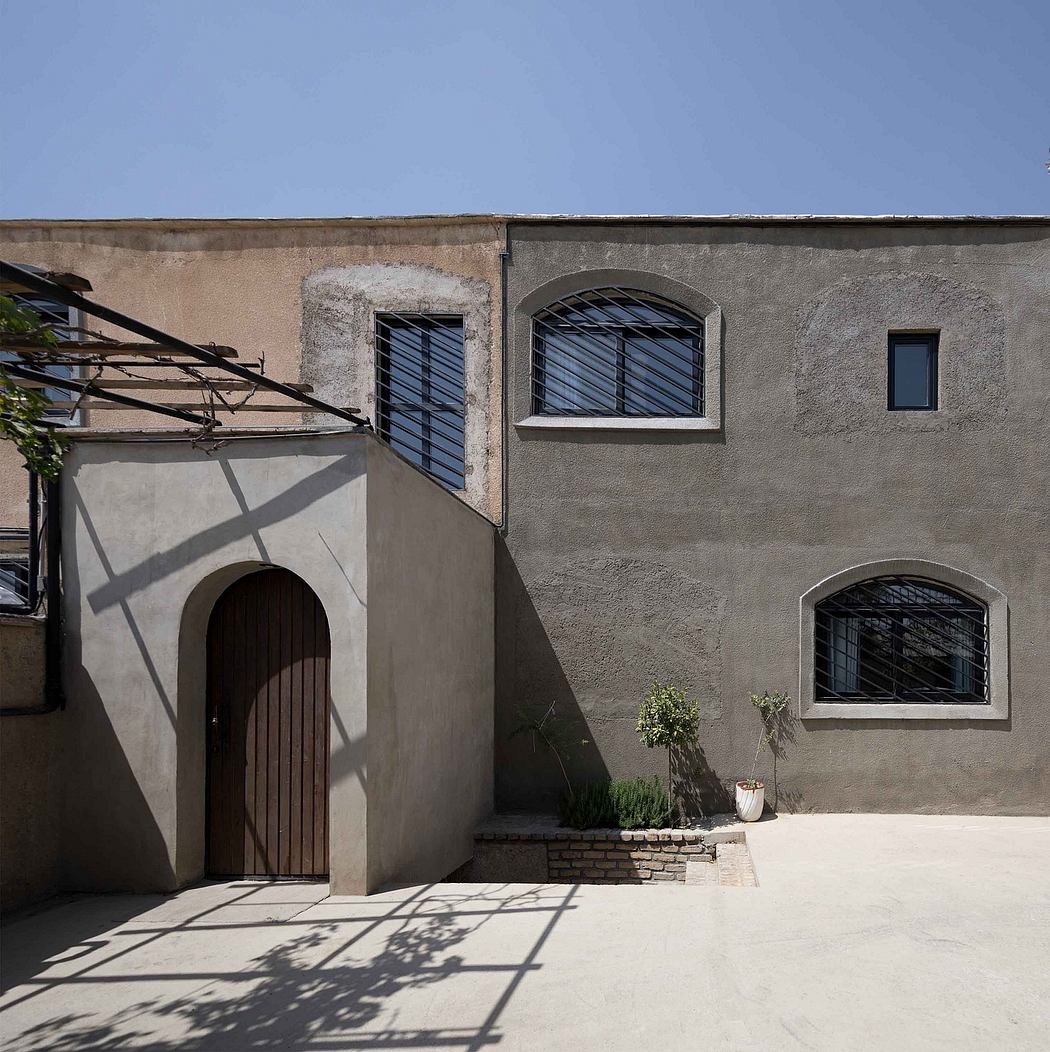 Facade of a modern building with arched windows and a wooden door.